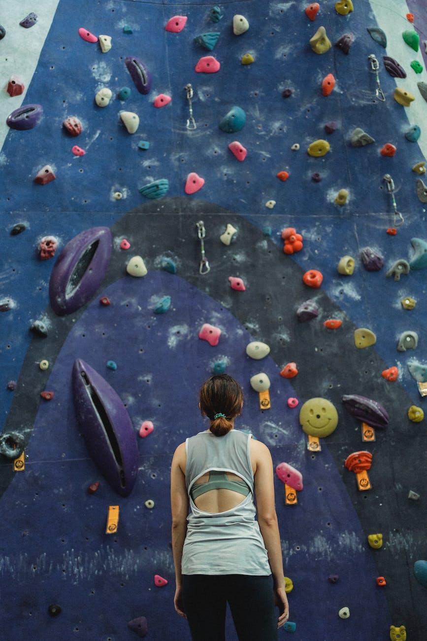 10 Achievable New Year's Resolutions for a Happier 2024 2 woman preparing for climbing high on wall