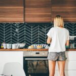 Building Your Dream Home: A Mix of Wisdom and Witty Mishaps 3 Young woman stands near modern kitchen at home.