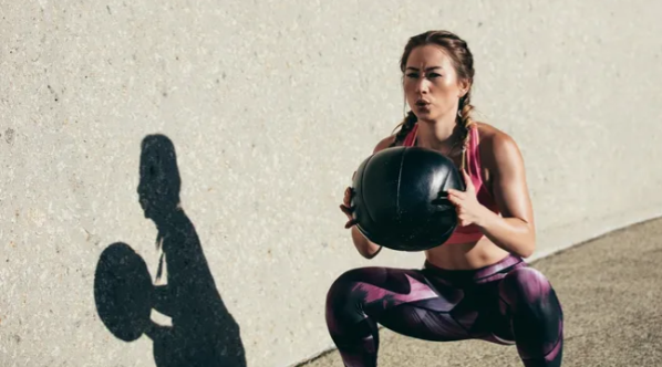 Elevate Your Bedroom Game with 15-Minute Workouts for Athletic Sex 11 Isometric Wall Squat with a Medicine Ball