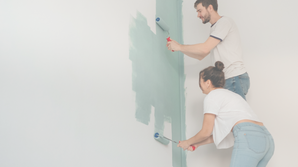 man and women painting a wall together