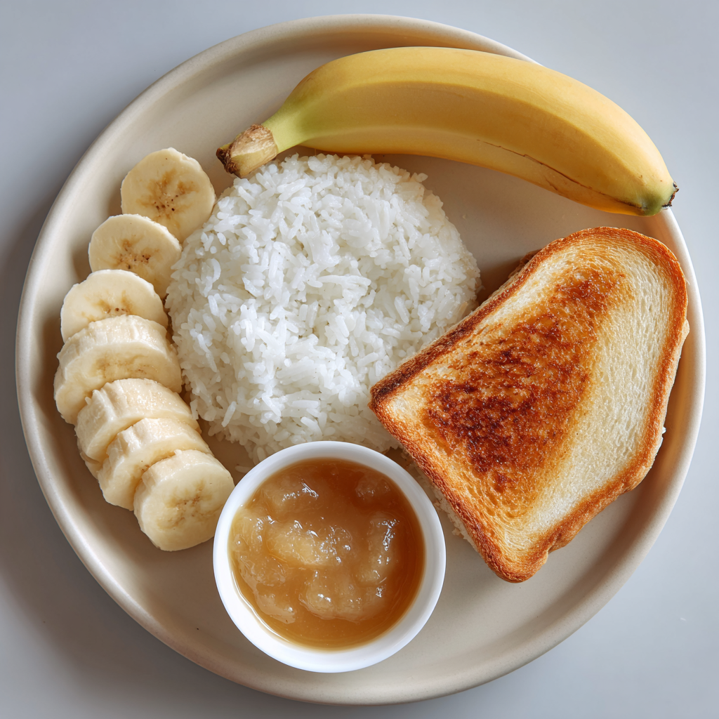 Banana, bowl of white rice, applesauce cup, and toast on a neutral plate.